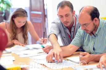 Anglų kalbos mokytojas, aiškinantis kažką mokiniui klasėje