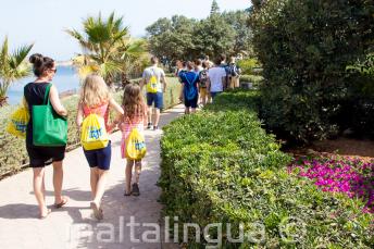 Mokytojas, vedantis mokinius į lauko anglų kalbos pamoką