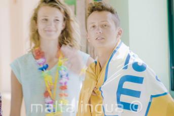 Paauglys, mokantis anglų kalbos, dėvintis mokyklos vėliavą