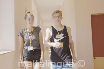 Paauglys berniukas ir mergaitė einantys pro kalbų mokyklą