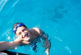 Studentas, plaukiantis šalia laivo Komino saloje.