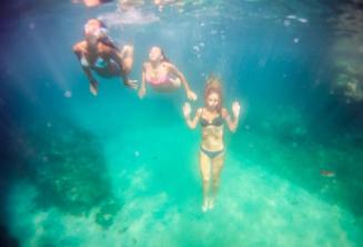 3 draugai plaukioja po vandeniu.