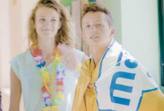 Paauglys, mokantis anglų kalbos, dėvintis mokyklos vėliavą